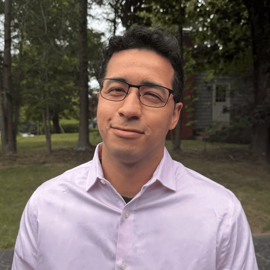 Dana, owner of Dane Digi, in glasses wearing a pink shirt outdoors